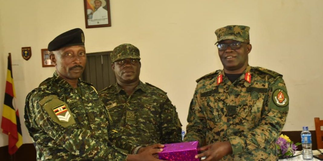 Brig-Gen-Paddy-Ankunda-awards-CPL-Kwezi-as-Maj-Sam-Wako-c-is-witnessing